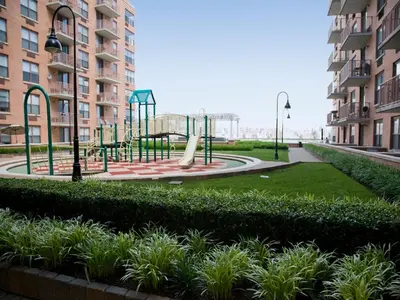 a playground in a park with a slide at Global Luxury Suites at Hoboken Waterfront in Hoboken