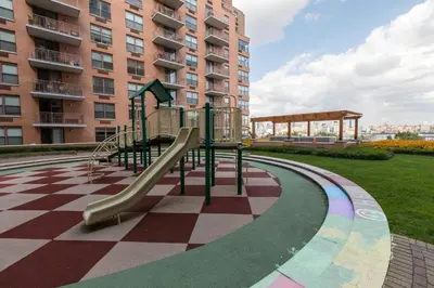 a playground in front of a tall building at Global Luxury Suites at Hoboken Waterfront in Hoboken