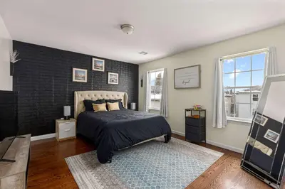 a bedroom with a bed and a brick wall at Newark Gem Pearl 3BR, 2BA - Sleeps 10 - Walk to Prudential Center and Newark Penn Station, Near EWR and American Dream Mall, includes WiFi - Laundry - Backyard - Gym in Newark