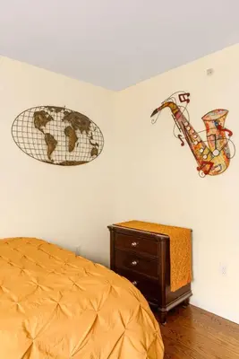 a bedroom with a bed and a clock on the wall at Newark Gem Pearl 3BR, 2BA - Sleeps 10 - Walk to Prudential Center and Newark Penn Station, Near EWR and American Dream Mall, includes WiFi - Laundry - Backyard - Gym in Newark
