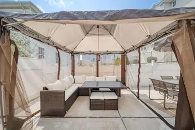 a tent with a couch and a table on a patio at Newark Gem Pearl 3BR, 2BA - Sleeps 10 - Walk to Prudential Center and Newark Penn Station, Near EWR and American Dream Mall, includes WiFi - Laundry - Backyard - Gym in Newark
