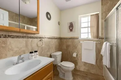 a bathroom with a sink and a toilet and a mirror at Newark Gem Pearl 3BR, 2BA - Sleeps 10 - Walk to Prudential Center and Newark Penn Station, Near EWR and American Dream Mall, includes WiFi - Laundry - Backyard - Gym in Newark