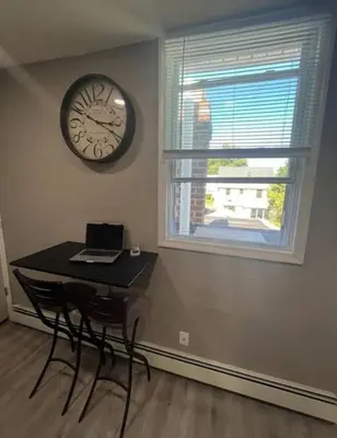 a room with a table and a clock on the wall at Cozy Apartment 2 BedroomS in Hillside