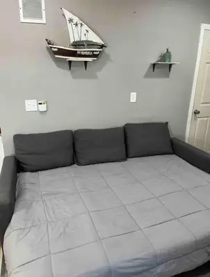 a couch with a toy boat hanging on a wall at Cozy Apartment 2 BedroomS in Hillside