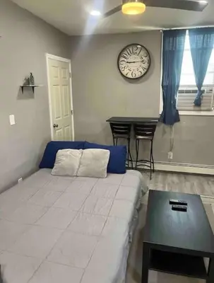 a living room with a bed and a clock on the wall at Cozy Apartment 2 BedroomS in Hillside