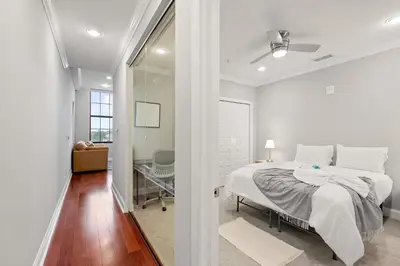 a white bedroom with a bed and a glass doorway at Luxury 1BR - Glass Wall & Window in Philadelphia