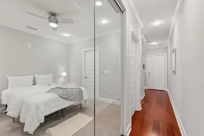 a white bedroom with a bed and a glass door at Luxury 1BR - Glass Wall & Window in Philadelphia