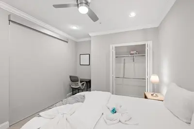 a white bedroom with a white bed with flowers on it at Luxury 1BR - Glass Wall & Window in Philadelphia