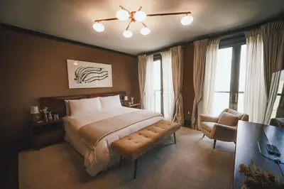 a bedroom with a bed and a chair and windows at Fasano Fifth Avenue I Private Members Club & Hotel in New York