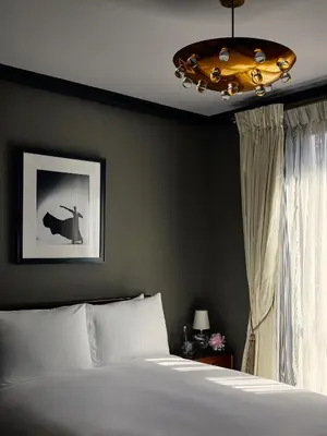 a bedroom with a bed and a chandelier at Fasano Fifth Avenue I Private Members Club & Hotel in New York