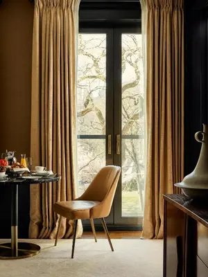 a chair and a table in front of a window at Fasano Fifth Avenue I Private Members Club & Hotel in New York