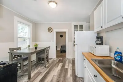 a kitchen with a table and a white refrigerator at Happiness in Harrison in Harrison
