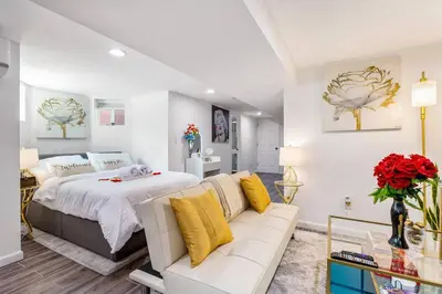 a bedroom with a white bed and a white couch at Luxury Suite by Prudential Ctr & 7min to EWR Airpt in Newark
