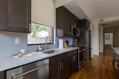 a kitchen with wooden cabinets and stainless steel appliances at Downtown Princeton Chic in Princeton