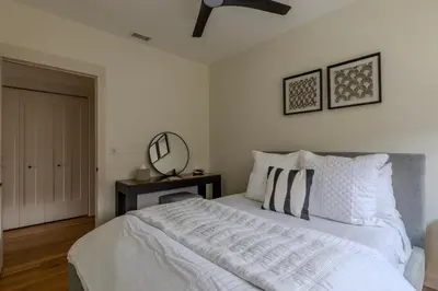 a bedroom with a white bed and a mirror at Downtown Princeton Chic in Princeton