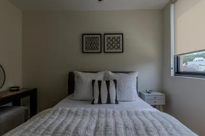 a bedroom with a bed with pillows and a window at Downtown Princeton Chic in Princeton