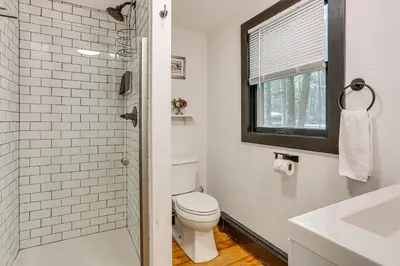 a white bathroom with a toilet and a sink at Walk to Mohican Lake Catskills Getaway with Dock! in Glen Spey