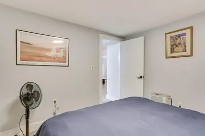a white bedroom with a bed and a fan at Walk to Mohican Lake Catskills Getaway with Dock! in Glen Spey