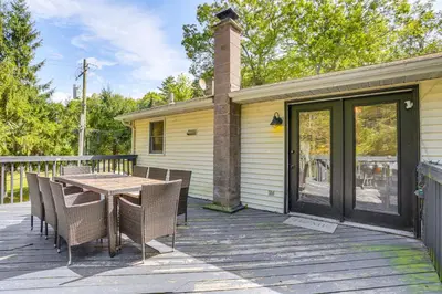 a patio with a table and chairs on a deck at Walk to Mohican Lake Catskills Getaway with Dock! in Glen Spey