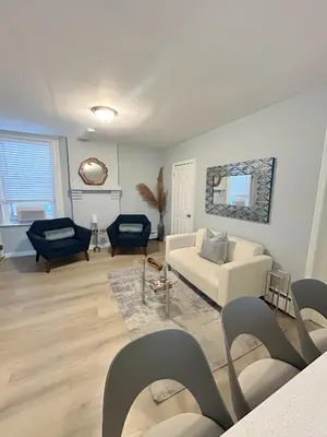 a living room with a white couch and chairs at Urban Zen in Montclair