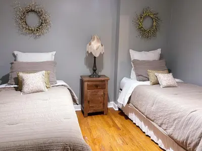 a bedroom with two beds and a lamp on a night stand at Urban Zen in Montclair
