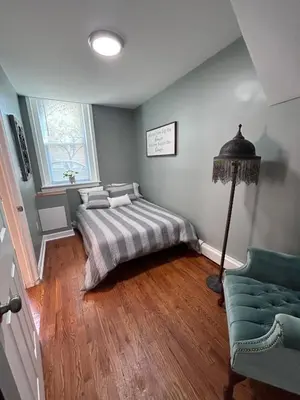 a bedroom with a bed and a lamp and a couch at Urban Zen in Montclair