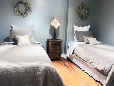 a bedroom with two beds and a nightstand and mirrors at Urban Zen in Montclair