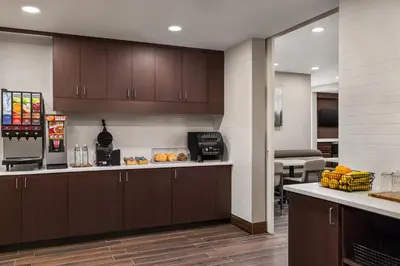 a kitchen with brown cabinets and a counter with food at Residence Inn by Marriott Mechanicsburg in Mechanicsburg