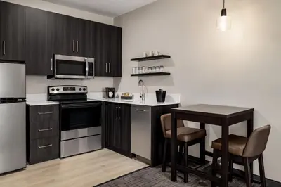 a kitchen with black and white appliances and a table at Residence Inn by Marriott Mechanicsburg in Mechanicsburg