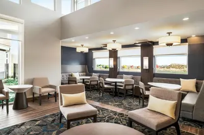a waiting room with tables and chairs and windows at Residence Inn by Marriott Mechanicsburg in Mechanicsburg