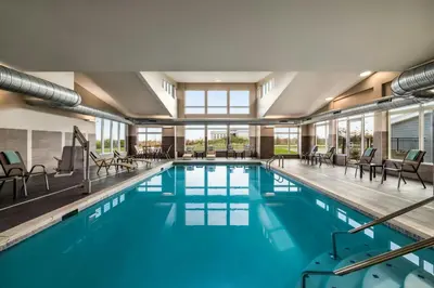 a large swimming pool with chairs and tables at Residence Inn by Marriott Mechanicsburg in Mechanicsburg