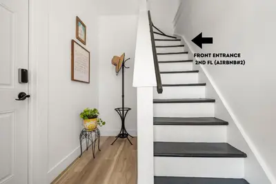 a staircase in a home with white walls and a door at NYC Access 4BR Duplex Sleeps 10, Free Parking in Fair Lawn