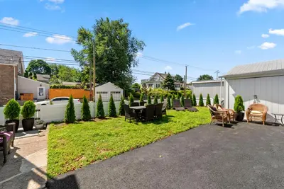 a yard with chairs and a table in a backyard at NYC Access 4BR Duplex Sleeps 10, Free Parking in Fair Lawn