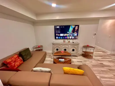 a living room with a couch and a flat screen tv at The Trendy Suite - Upgraded 2BR with Luxe Amenities in Paterson