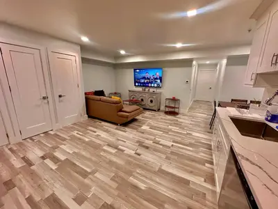 a living room with a couch and a flat screen tv at The Trendy Suite - Upgraded 2BR with Luxe Amenities in Paterson