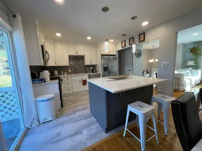 a kitchen with white cabinets and a large island with stools at Welcome to our Retreat Haven in Warwick, NY in Warwick