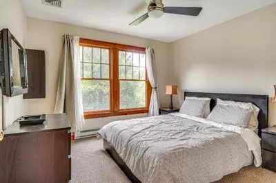 a bedroom with a bed and a tv and a window at Tannersville Resort Home with Deck and Gas Grill! in Tannersville
