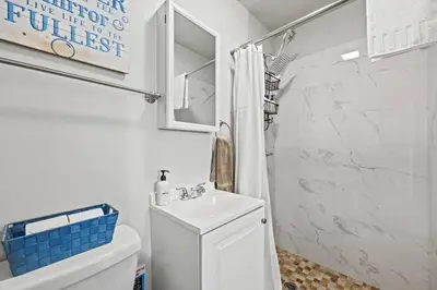 a white bathroom with a toilet and a sink at Central Location Studio, Walk to Times Square in New York