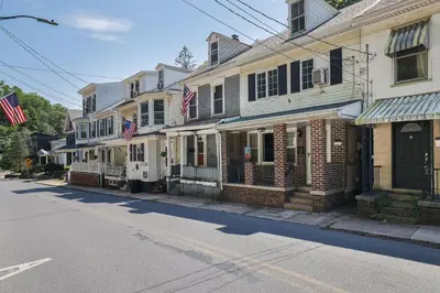 a row of houses on a street with american flags at Home on Broadway in Jim Thorpe in Jim Thorpe