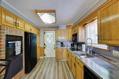 a kitchen with wooden cabinets and a black refrigerator at Home on Broadway in Jim Thorpe in Jim Thorpe