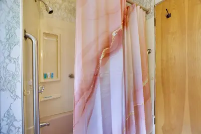a shower with a pink shower curtain in a bathroom at Home on Broadway in Jim Thorpe in Jim Thorpe