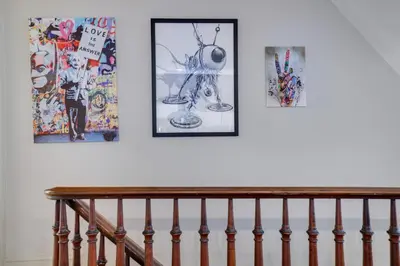 a staircase with four pictures on a white wall at In The Heart Of Jim Thorpe (with your own parking) in Jim Thorpe
