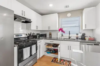 a kitchen with white cabinets and a stove top oven at Luxury Gated home near NYC and EWR with free Parking in Elizabeth