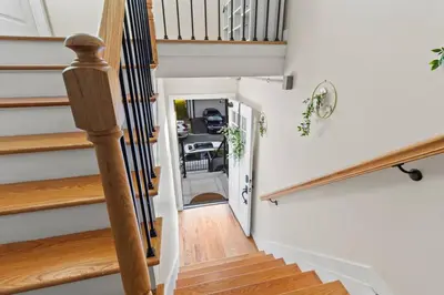 a staircase in a home with white walls and wood floors at Luxury Gated home near NYC and EWR with free Parking in Elizabeth
