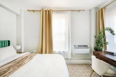 a bedroom with a bed and a desk and a window at 73-1504 Newly Reno Studio UWS Doorman Gym Laundry in New York