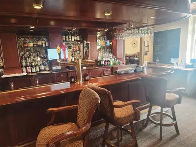 a bar in a pub with two chairs and a counter at Moselem Springs Golf Club in Kutztown