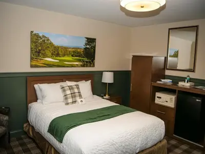 a bedroom with a bed and a golf course painting on the wall at Moselem Springs Golf Club in Kutztown