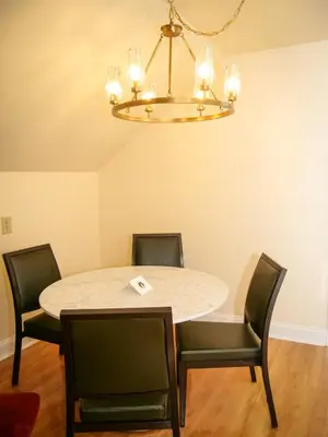 a dining room with a table and chairs and a chandelier at Moselem Springs Golf Club in Kutztown