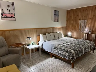 a bedroom with a bed and a couch and a chair at High Point Mountain Motel in Wantage