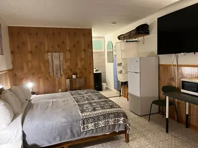 a bedroom with a bed and a refrigerator and a television at High Point Mountain Motel in Wantage